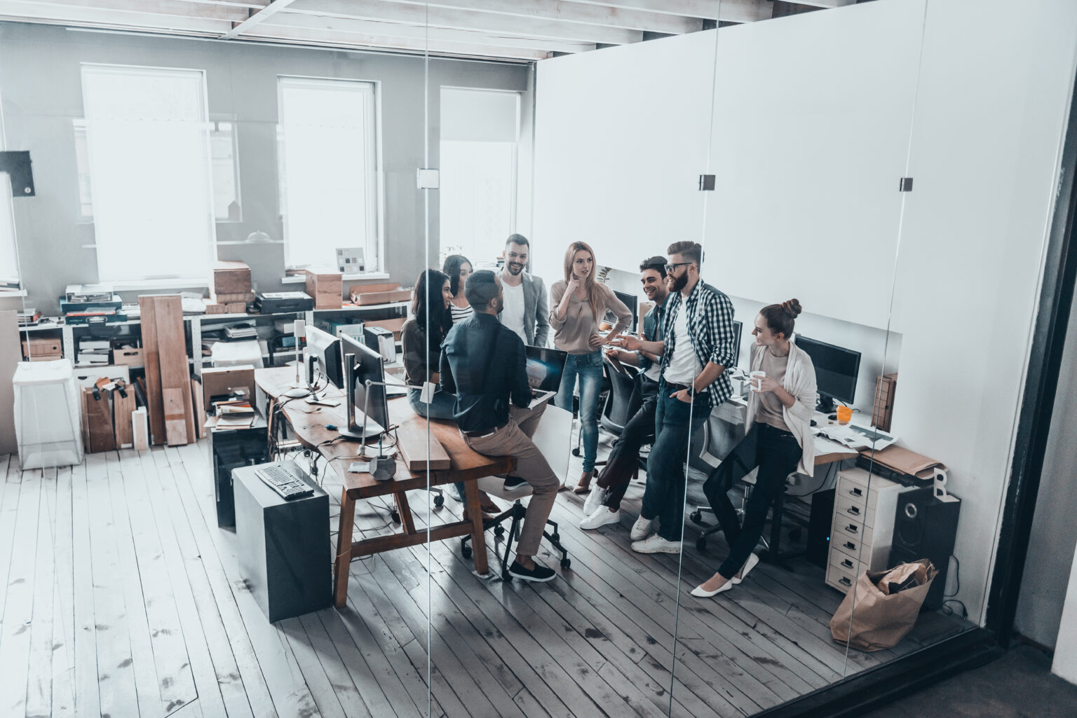 cooperation in action. full length top view of young business people in smart casual wear talking and smiling while having a brainstorm meeting in office